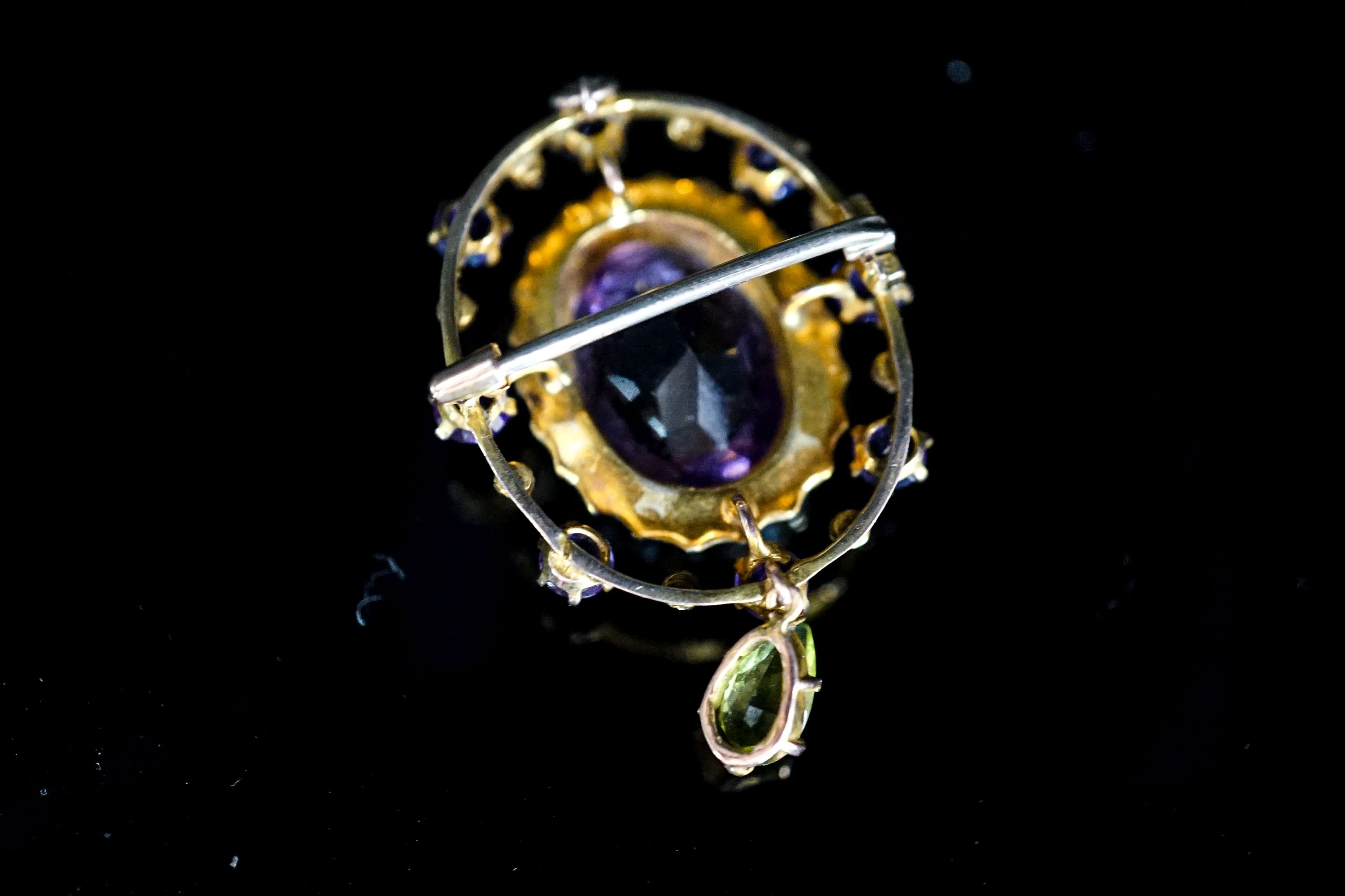 An early 20th century yellow metal, amethyst and peridot set drop oval brooch, in the suffragette colours, 35mm, gross weight 4. 6 grams.